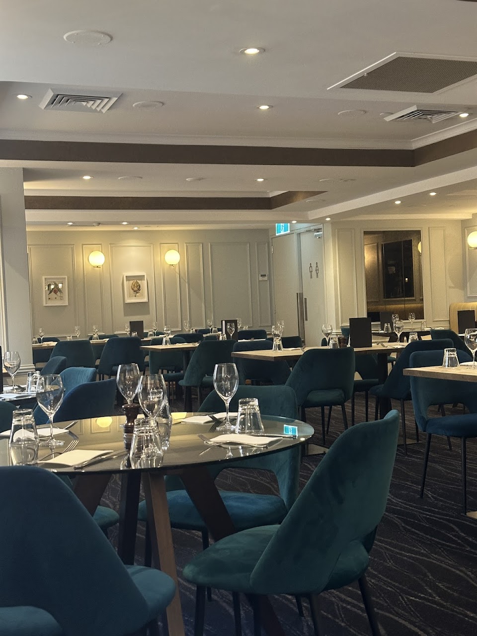 Quartier Bistro & Bar dining room with teal chairs and set tables
