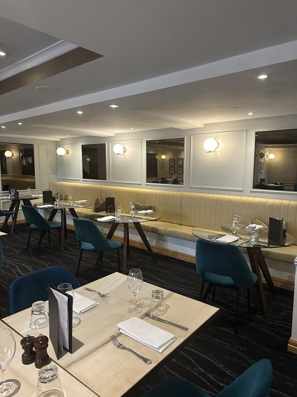 Banquette seating and round tables inside Quartier Bistro & Bar