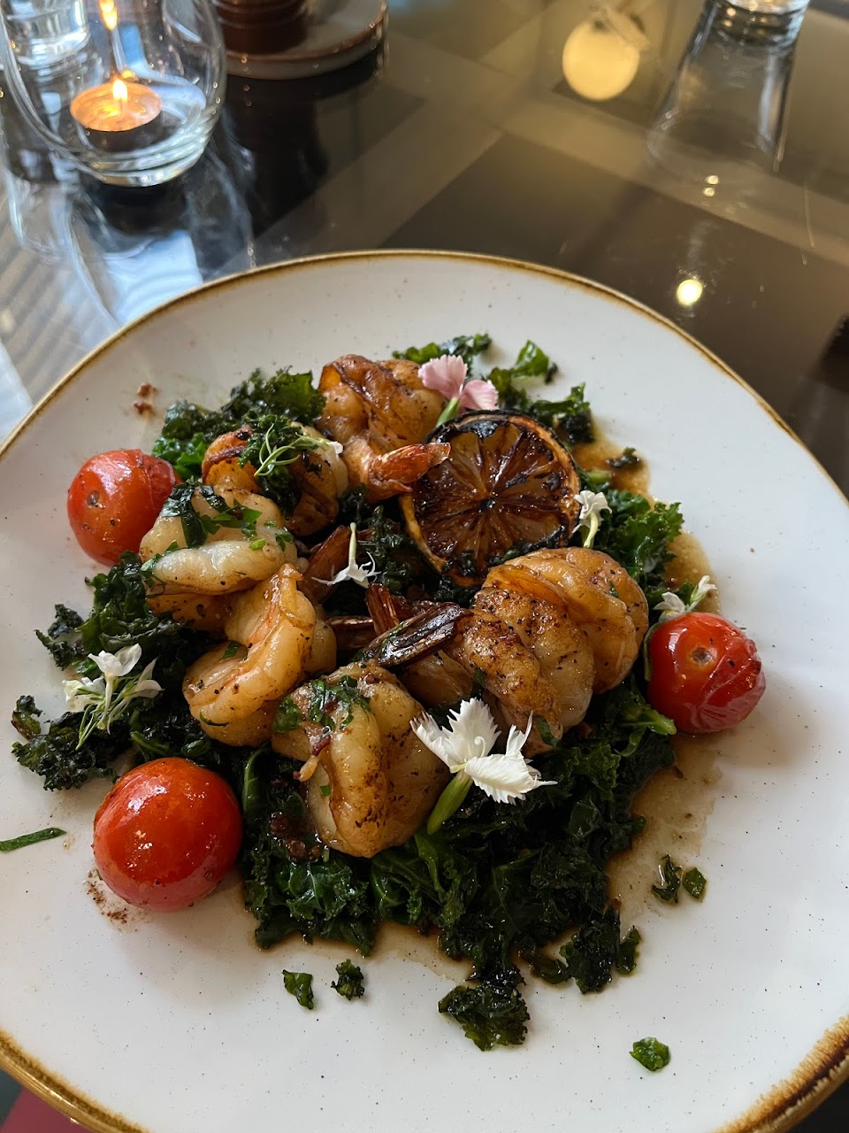 Prawn dish with greens, tomato and charred lemon