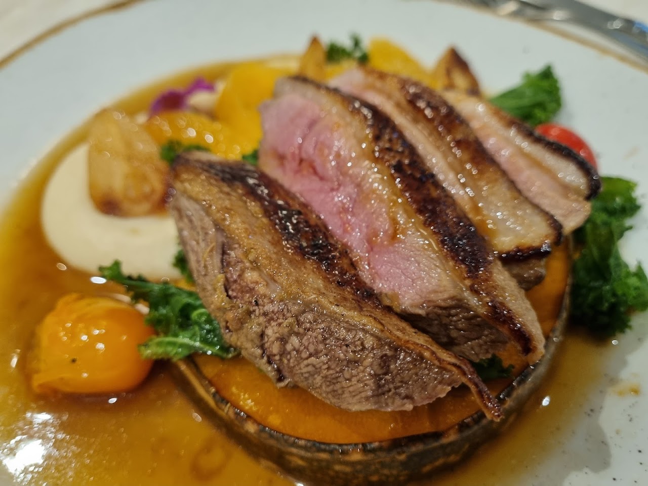 Sliced duck or steak main with vegetables and sauce